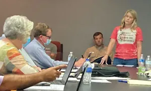 A Monroe County citizen standing to address the Monroe County School Board at a meeting table